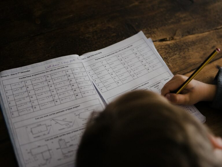 Child writing math problems at a desk
