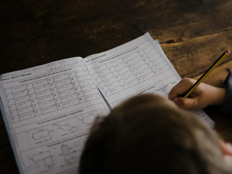 Child writing math problems at a desk