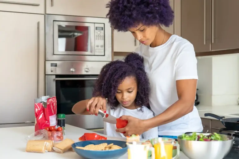 Parent and young child preparing food together in the kitchen, building practical life skills through cooking