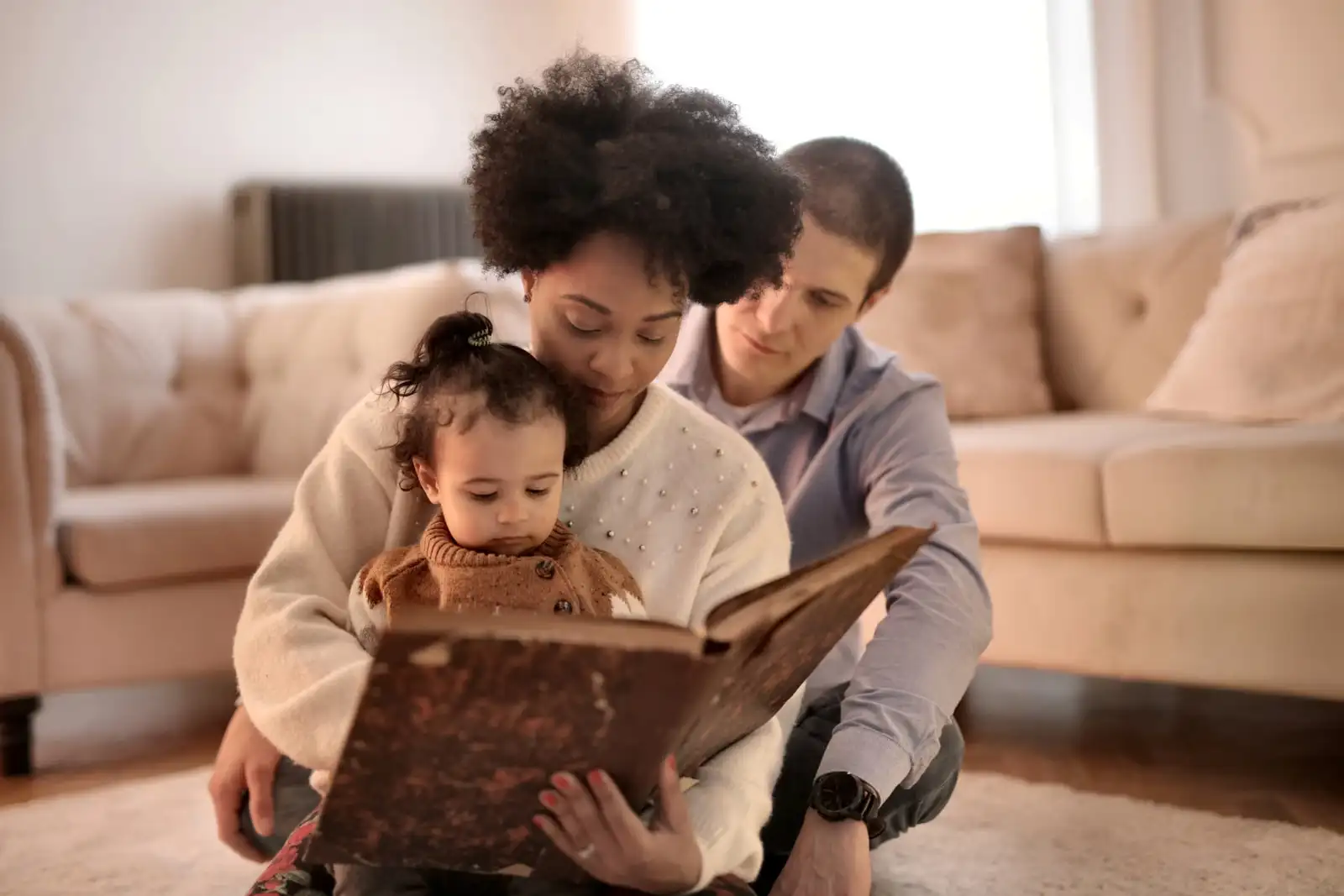 Both parents reading a picture book with their toddler